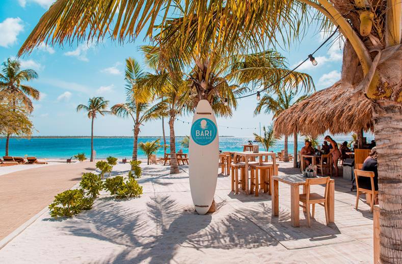 Tropische beachclub bij Chogogo Dive & Beach Resort Bonaire met decoratieve surfplank